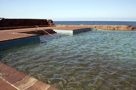 Natural pool with stairs, and the ocean in the background located in the Spanish town of Tabaiba