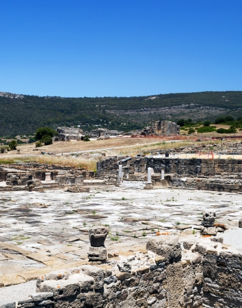 Remains of Roman civilization formed by columns in the ruins of Baelo Claudia in the Spanish province of Cadiz, are the mountains in the background, its a vertical imageの写真素材