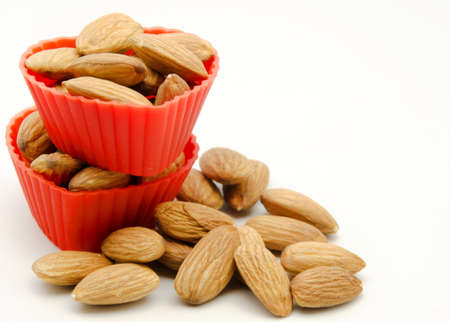 Several raw almonds into molds shaped red heartの写真素材