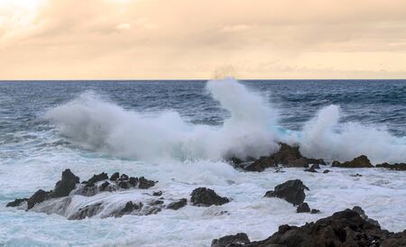 Waves in the sea surrounded by volcanic rocks