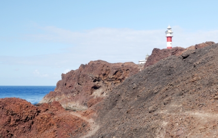 Beach next to a hillside with rocks in the sea in the village of Tenerifeの写真素材