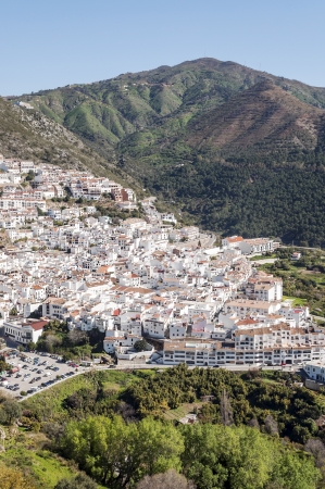 White village called ojer located in the Spanish province of Malaga with blue sky is surrounded by mountains, see the town from a viewpoint it´s a vertical imagenの写真素材