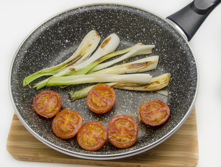 scallions and roasted cherry tomatoes served on a plateの写真素材