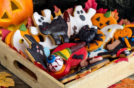 Close-up of bright and delicious halloween cookies with different decoration in wooden basketの写真素材