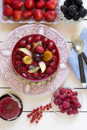 Top view of delicious pie with fresh berries and pear on cakestandの写真素材