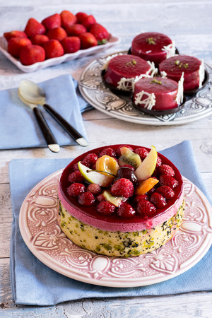 View of delicious bright fruit cake against of strawberry and jelly tartsの写真素材