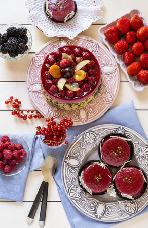above view of delicious homemade pie with fresh fruit and berries with jelly tarts on tableの写真素材