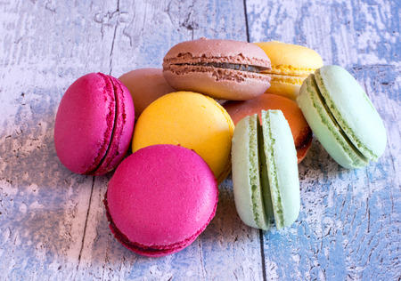 Close-up of fresh colorful macaroon dessert on blue wooden tableの写真素材