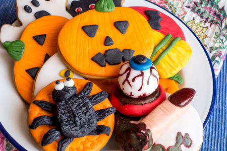 Above view of creative fondant cookies with halloween spider,witch finger,pumpkin and bloody eyesの写真素材