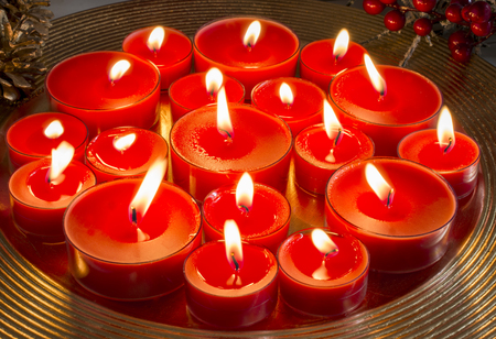 Christmas candles burning on golden plateの写真素材