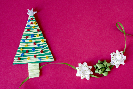Handmade product colorful christmas tree and three bows on pink background. Copyspace.の写真素材