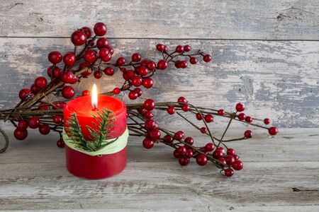 Cranberry and a lit candle. Still-life.の写真素材
