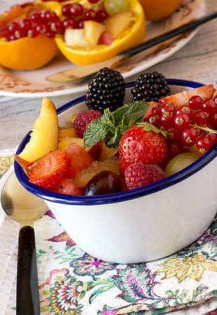 Summer fresh berries and fruit in metal bowl on towel with spoonの写真素材