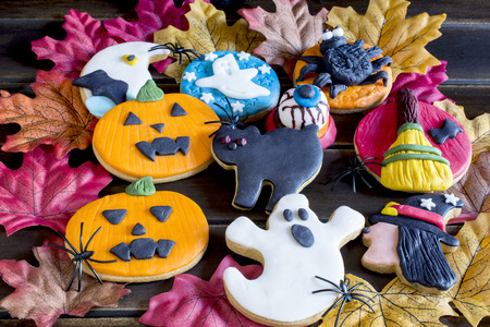 Top view of sweet halloween cookies on autumnal leaves の写真素材