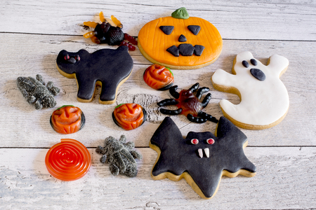 Top view of sweet halloween cookies with icing and fruit jelly on wooden ground.の写真素材