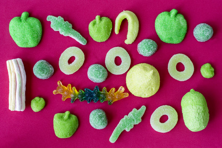 Green jelly sweets on a red backgroundの写真素材