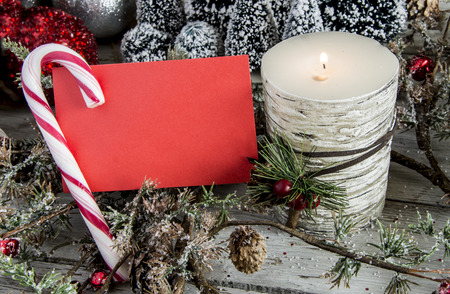 Sheet of red paper with candy cane and candle. Horizontal studio shotの写真素材