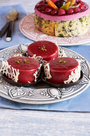 Close-up of bright jelly mini cakes on plate over blue towel.Fruit and berry cake on background.の写真素材
