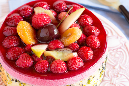 Homemade cake with jellied fruit and berries in daylightの写真素材
