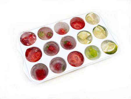 Ice cubes with strawberries lemons and limeの写真素材