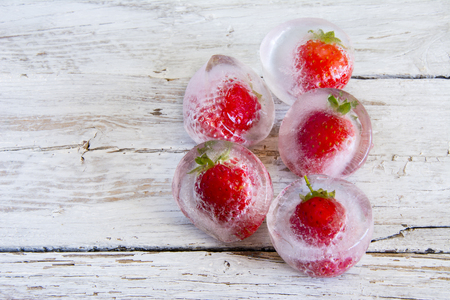 Ice cubes with frozen strawberriesの写真素材
