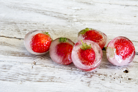 Ice cubes with frozen strawberriesの写真素材