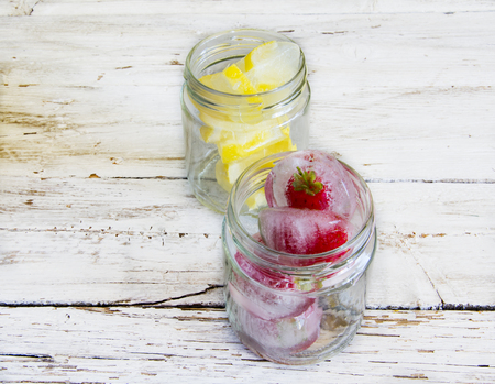 Ice cubes with lemons and frozen strawberriesの写真素材