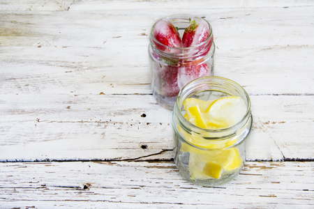 Ice cubes with lemons and frozen strawberriesの写真素材