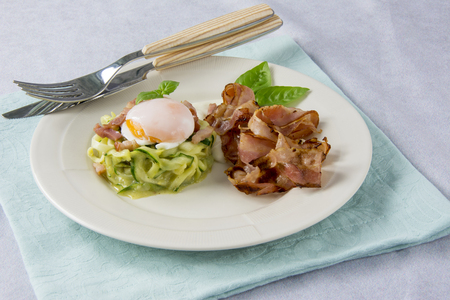 Scrambled eggs with zucchini, carbonara sauce and baconの写真素材