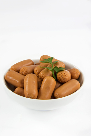 Raw appetizer sausages served in a bowl on white backgroundの写真素材