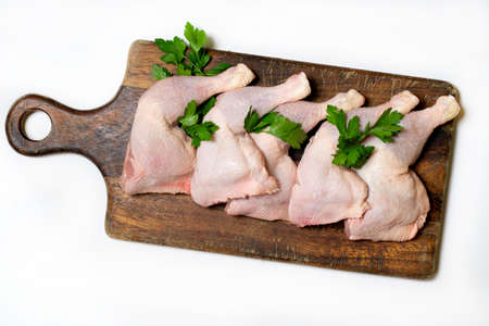 Raw chicken thighs on a wooden boardの写真素材