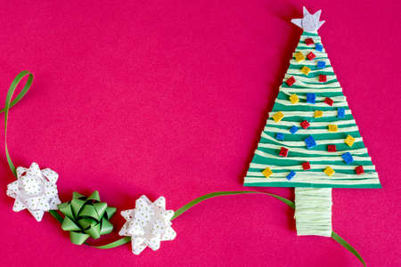 Paper decoration christmas tree and three bows on pink background. Copyspace.の写真素材