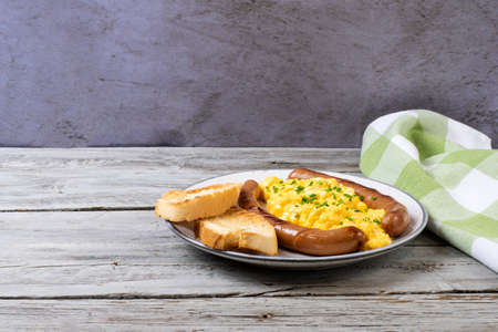Scrambled eggs with sausages served on a plate