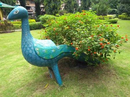 artificial peacock with tree tail in the greenery filled garden.の写真素材