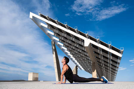 Male Caucasian sportsman in a gray tank top touches his neck with a gesture of pain or concern on his face with a gray background and a nice lightの写真素材