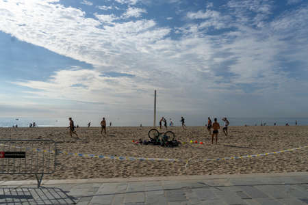 BARCELONA; SPAIN - MAY 25th 2020: First day of the phase 1 of the coronavirus disease (COVID-19) in Barcelona, people who take advantage to go outdoors. Group of friends playing volleyballのeditorial素材