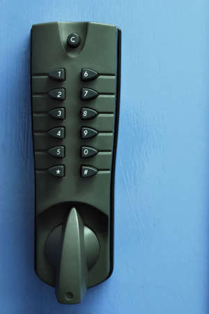 Grey security numbered door lock against blue doorの写真素材