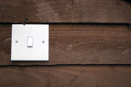 Royalty free stock image of white light switch against wood background with copyspace to the rightの写真素材