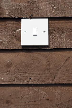 Royalty free stock image of white light switch against wood background with copyspace beneathの写真素材