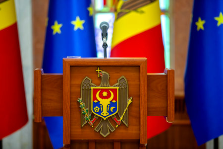 The coats of arms of Republic of Moldova, the official symbol of the state on central tribune in the presidential palace with flag of European Union and flag of Republic of Moldova.の写真素材