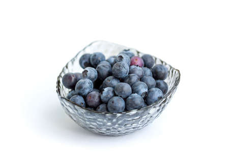 selective focus of fresh blueberry in glass bowl isolated on white backgroundの写真素材
