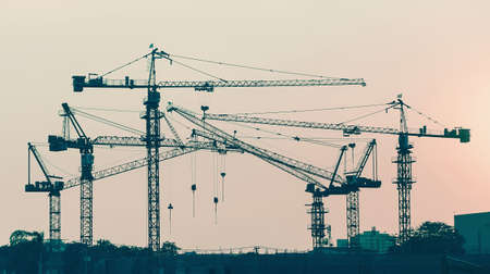 construction tower crane in vintage tone color with sunset sky backgroundの写真素材