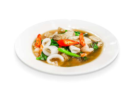 thai food fried noodle with seafood squid, sea mussel, shrimp, mushroom and kale soaked in gravy isolated on white backgroundの写真素材