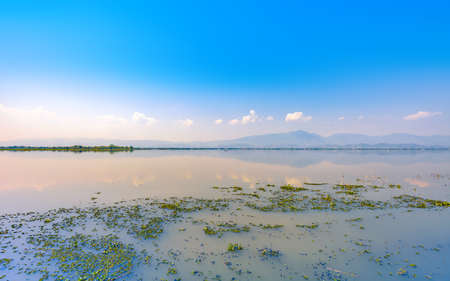 calmness lake in the morning with mountain and reflection in the water, Kwan Phayao or Phayao Lake Northern of Thailandの写真素材