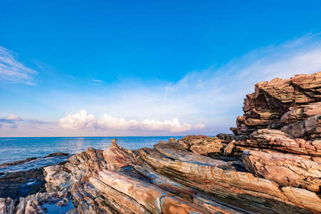 Rocky seashore canyon in morning sunrise with bright blue sky and clouds at Khao Laem Ya National...