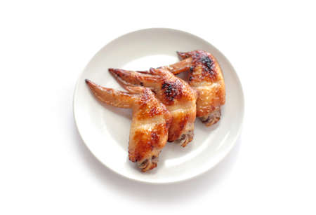 Grilled chicken wings on white plate isolated on white backgroundの写真素材