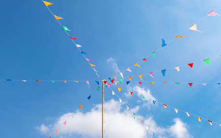 colorful of Thai style fancy flag strips on bright blue sky background that is made for faith or...