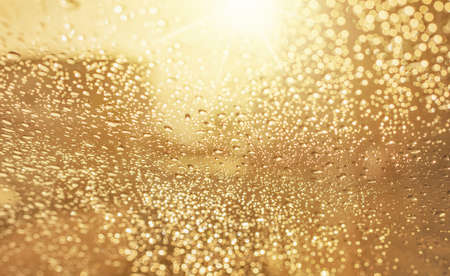 Droplets of rain on car wind shield reflection with glow sunlight in morning rainydayの写真素材