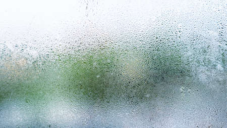Water droplets condensation or steam background on glass after rainning in rainy day