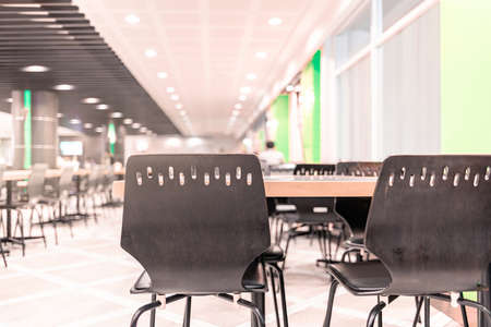 Modern interior of cafeteria or canteen with chairs and tables, eating room in selective focusの写真素材